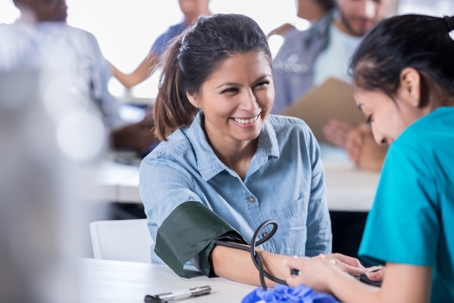Volunteer nurse checks patient's blood pressure